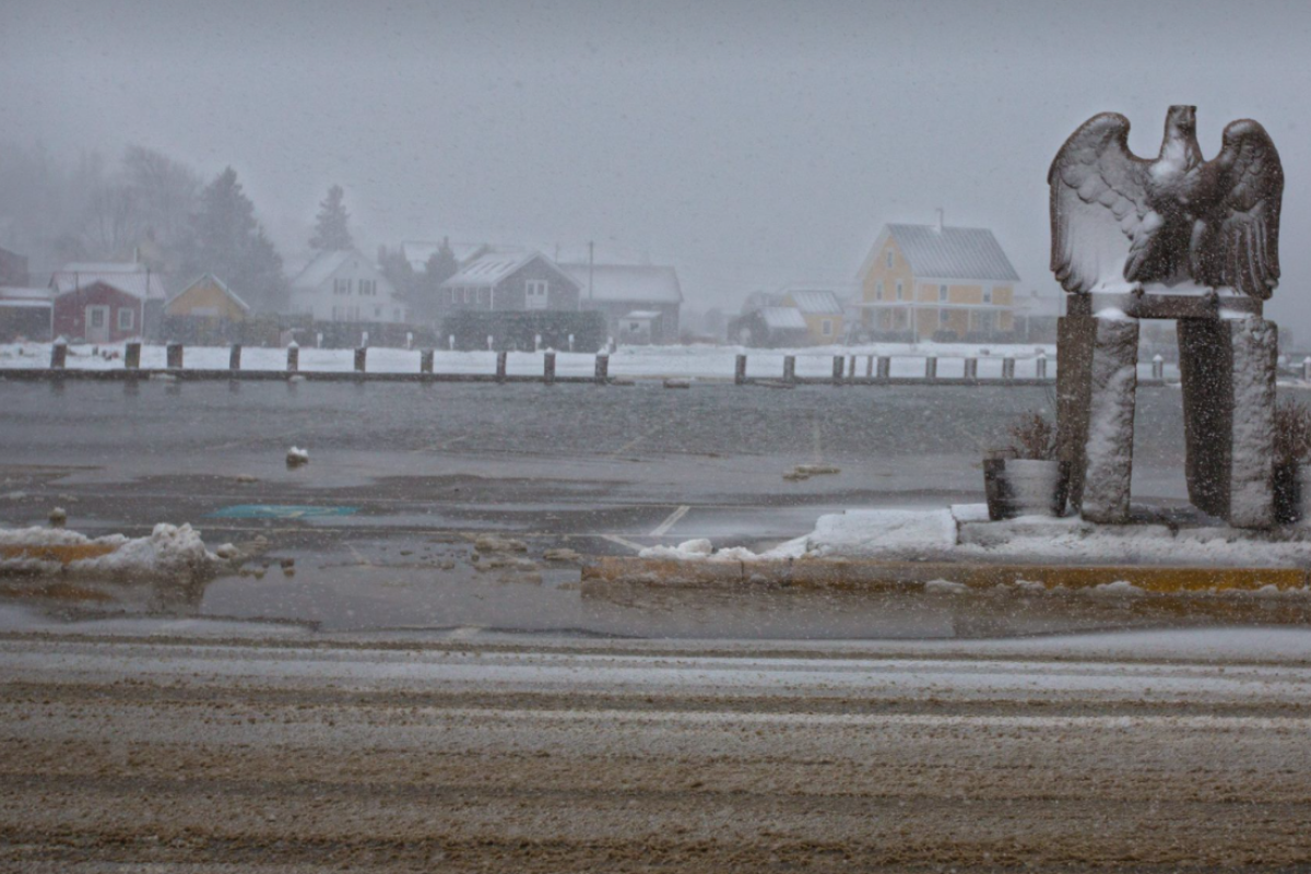 winter flood over the downtown parking lot with the Vinalhaven granite eagle in the foreground, gray foggy sky